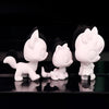 Three white printable bobble head figurines displayed against a black reflective surface.