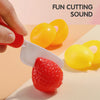 A hand is using a white tool to cut a red strawberry, demonstrating a fun cutting sound for an educational toy.