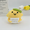 A yellow crocheted lemon ornament with a green top and a small white tag featuring a positive message.