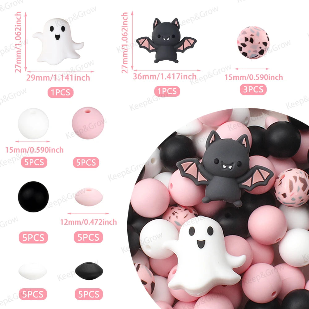 A collection of black and pink silicone crafting beads, including ghost shapes and round spheres.