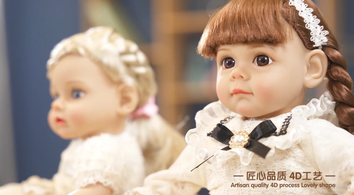 A close-up of a realistic 4D process baby doll with brown hair and a white outfit.