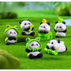 A set of adorable resin panda figurines in various colors sitting on green grass.