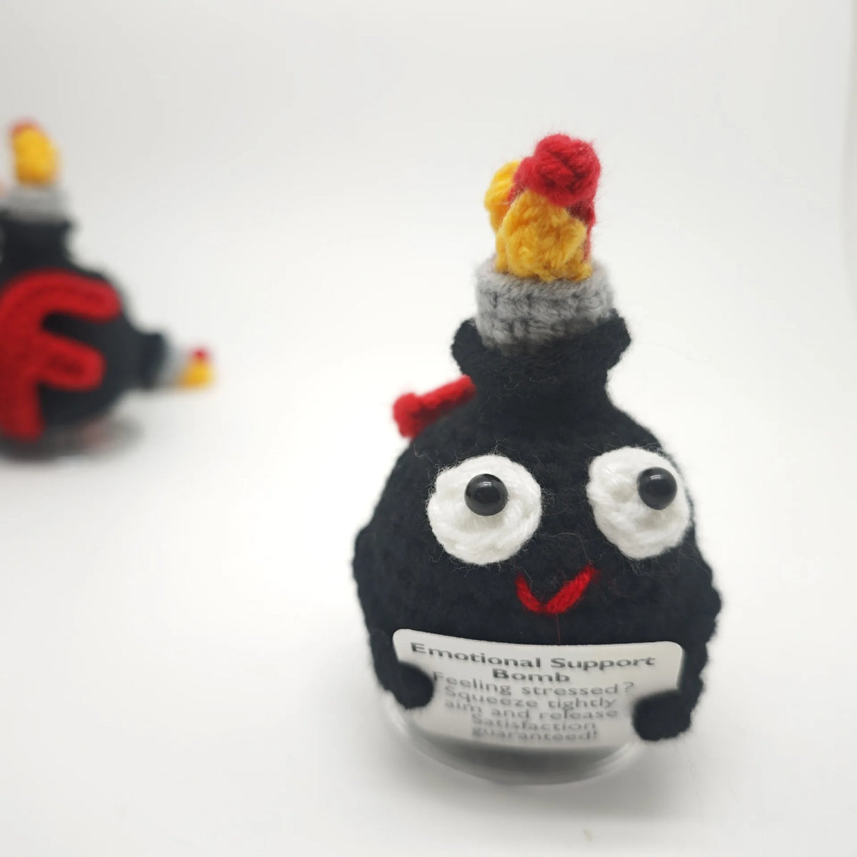 Handmade crochet F-bomb doll with an encouragement card featuring a black body and a red, yellow, and gray head.