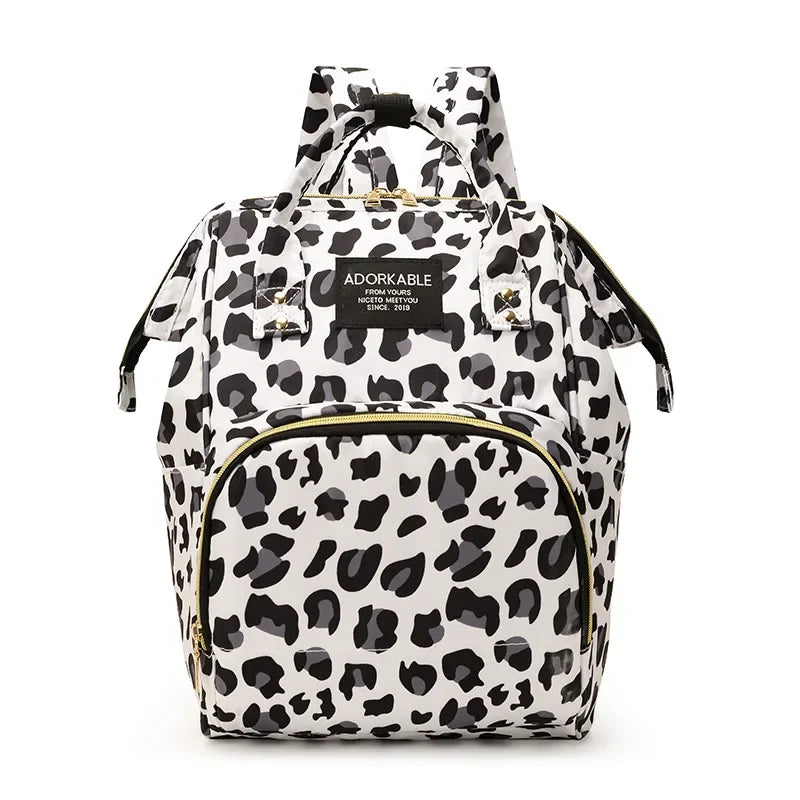 A black and white leopard print waterproof diaper bag with a backpack design.