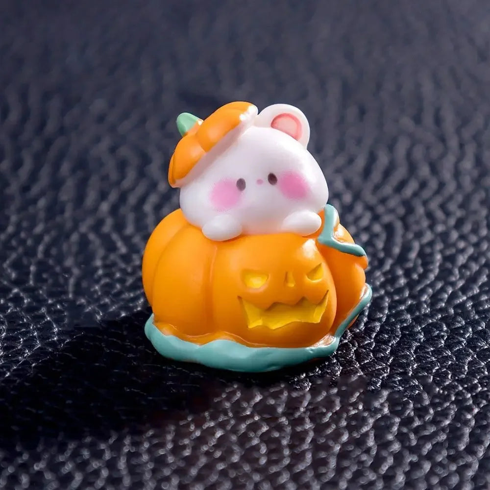 An orange and white cartoon bear pumpkin figurine with pink accents displayed on a dark surface.