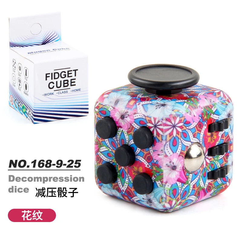 A colorful fidget cube with a floral design and magnetic buttons is shown next to its packaging.