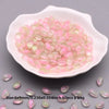 A white dish filled with pink and clear water drop glass beads for jewelry making
