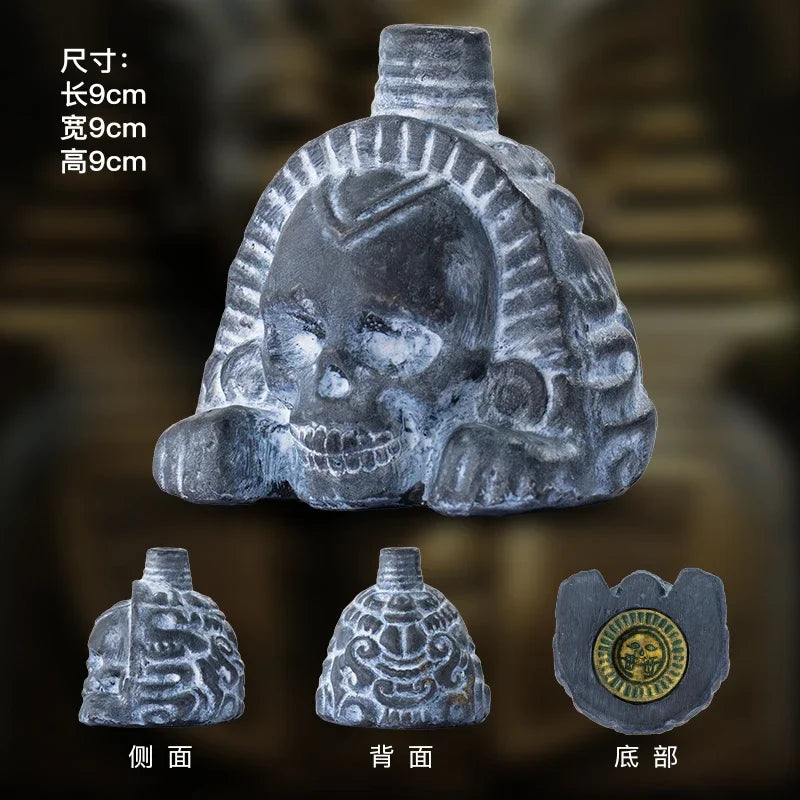 A handcrafted Aztec death whistle made of grey stone, shown from the front, back, and top views.