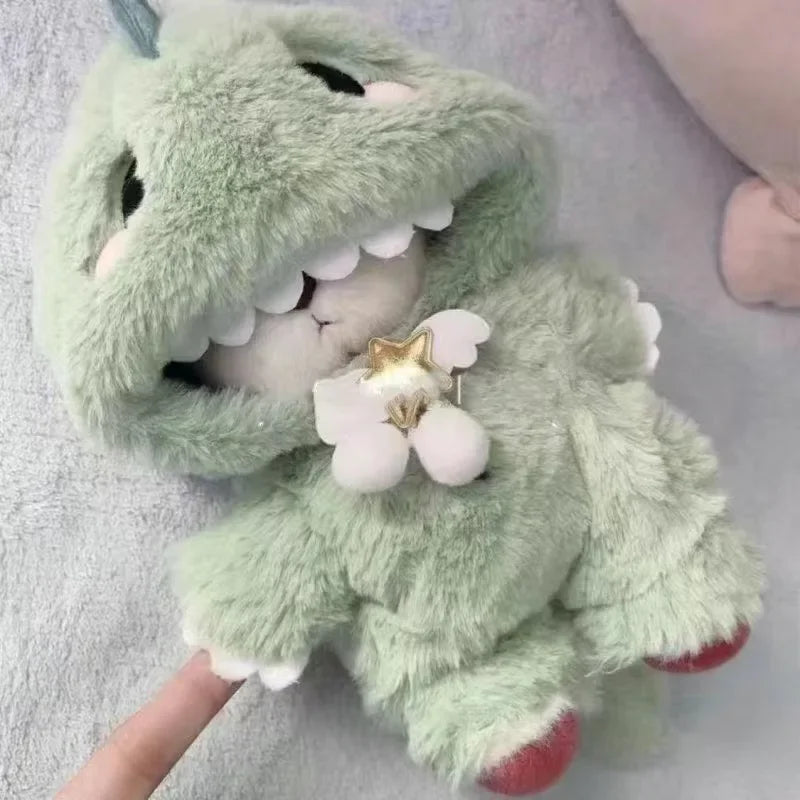 A soft green plush toy resembling a dragon or creature with white teeth and a gold star accessory.