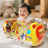 A baby is smiling while interacting with a yellow Montessori baby crawling roller toy.