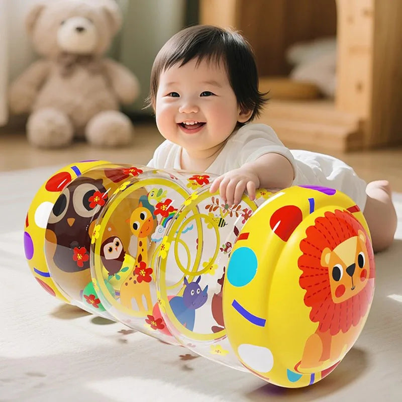 A baby is smiling while interacting with a yellow Montessori baby crawling roller toy.