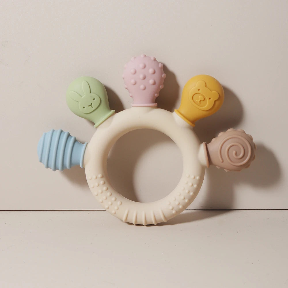 Set aus Silikon-Baby-Teether-Ringen in Pastellfarben, darunter rosa, gelb und grün.