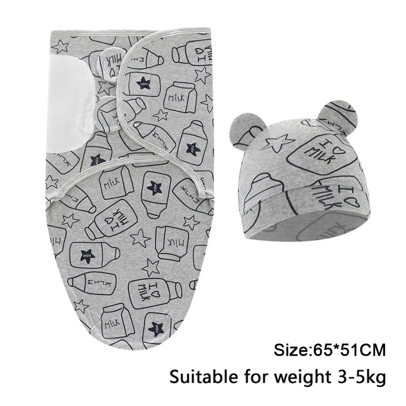 A gray cotton newborn swaddle blanket and hat set featuring milk-themed stars and text