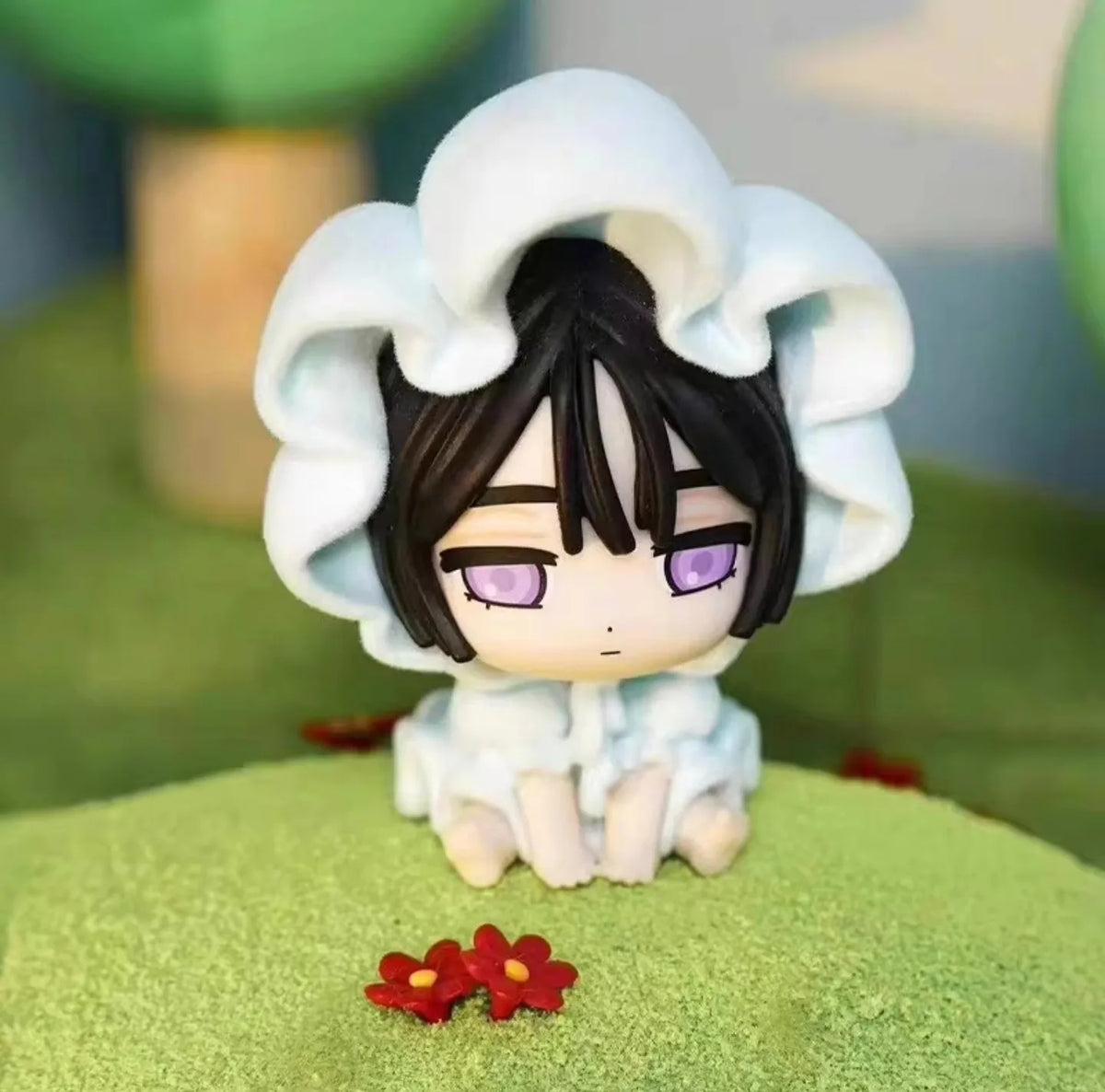 A white blind box mini figure collectible with black hair and purple eyes wearing a fluffy white hood.