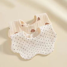 A set of white baby bibs featuring various textures and patterns including polka dots and rainbow designs.
