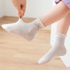 A hand is holding a white bow sock on a foot, showing the texture and fit of the breathable cotton socks.