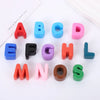 A collection of colorful acrylic letter beads in uppercase alphabet form arranged in a row.