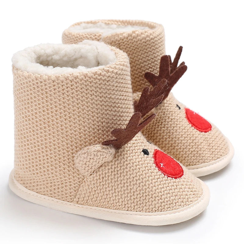 A pair of beige knitted baby first walker shoes shaped like cute animals with faux fur trim and wooden antlers.