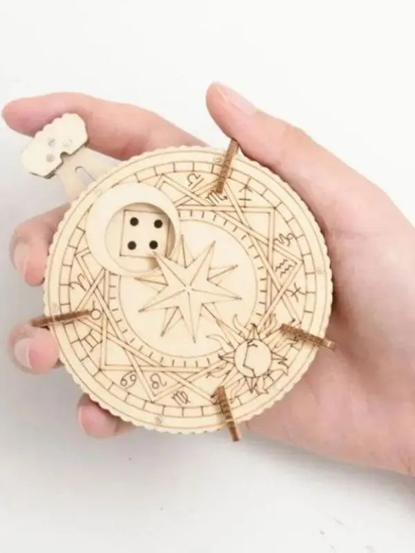 A hand holds a circular wooden puzzle kit with intricate lines and a small wooden piece.
