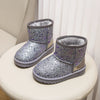 A pair of sparkly silver winter snow boots with faux fur lining displayed on a white surface.