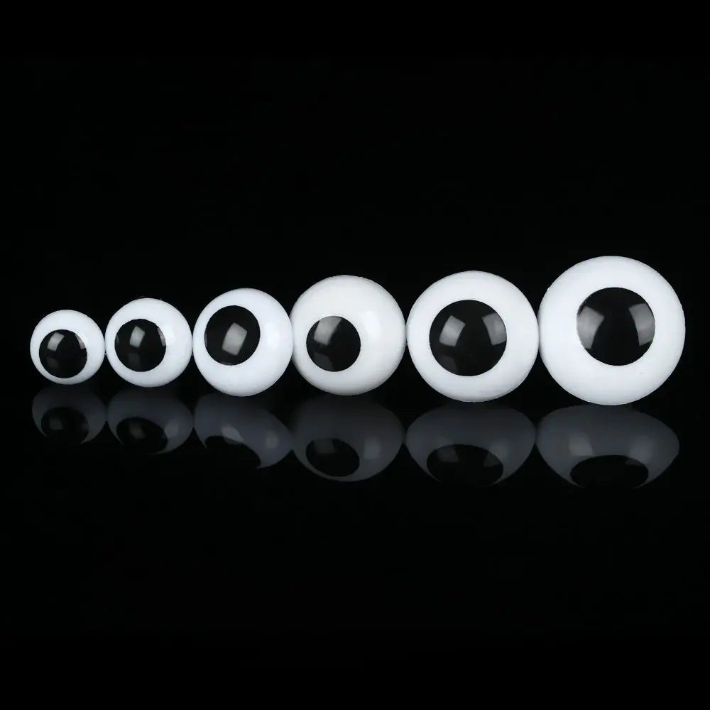 A row of glossy white plastic safety eyes for amigurumi and stuffed animals