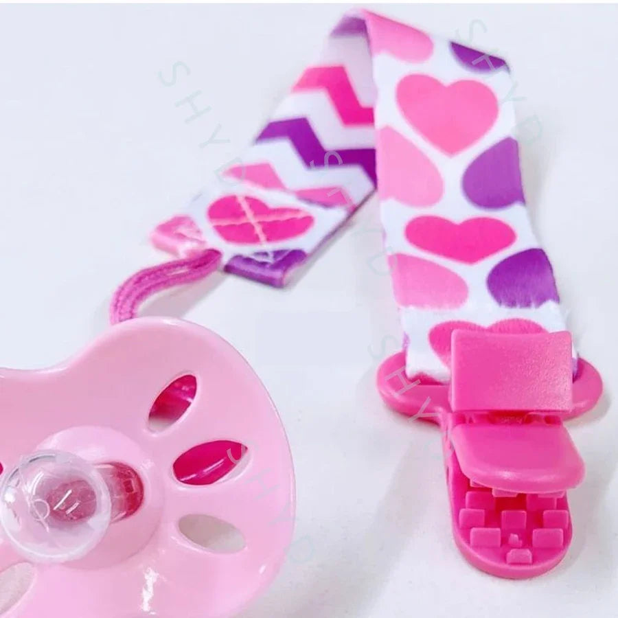 Pink pacifier clips with double-sided prints featuring hearts in pink and purple patterns
