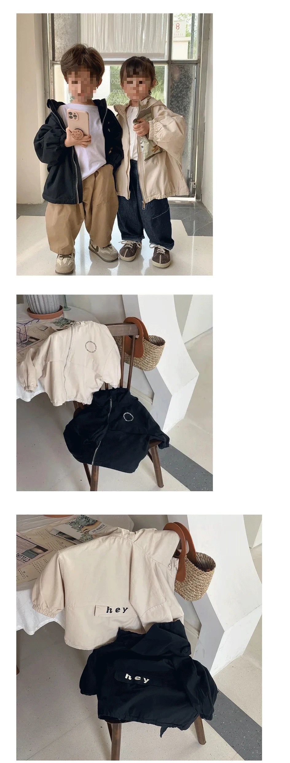 A black hooded zip-up jacket with a white letter print is displayed on a wooden chair.