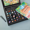 A gift box containing a collection of natural crystals and minerals, displayed alongside an open book.