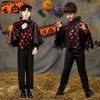 Two children in black vampire bat costumes with capes and accessories posing against a textured background.