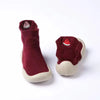 A pair of maroon baby first walker socks shoes with a small red fruit decoration.