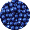 A close-up view of small, dark blue imitation pearl beads scattered in a pile.