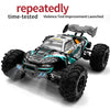 A black and teal brushless 4WD monster truck RC car with LED headlights is shown on a white surface.