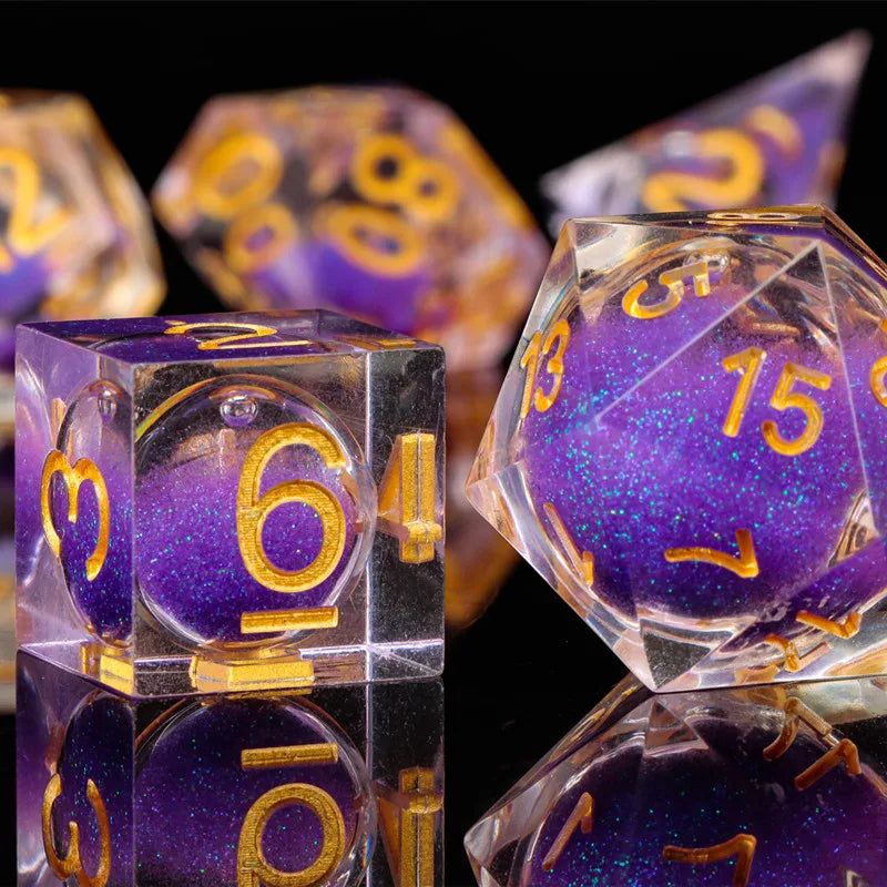A close-up of a set of translucent purple and gold polyhedral dice used for tabletop gaming.