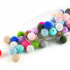 A clear glass mold filled with various colored silicone round beads for jewelry making and DIY crafts