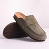A pair of olive green suede cork mules shown with the sole visible.