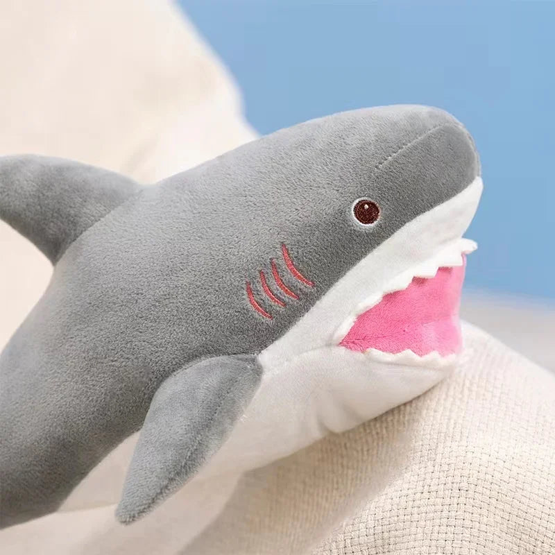 A gray and pink plush toy depicting a killer whale and a great white shark.