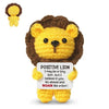 A yellow crochet lion doll with brown fur and a card that reads I may be a tiny lion but I believe in you go ahead and roar l