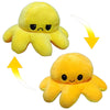 A pair of yellow, double-sided flip octopus plush toys, one frowning and one smiling.