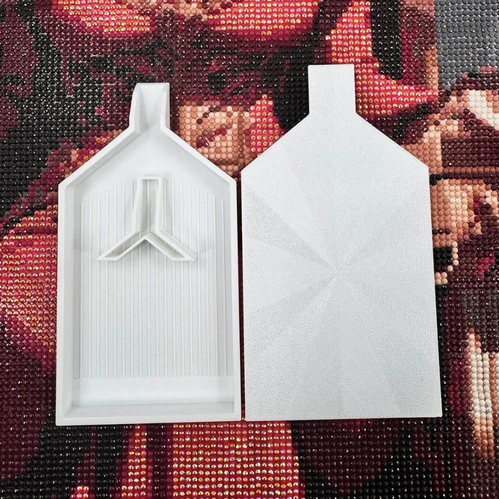 A white diamond painting tray with a pop-up plug is displayed against a dark, textured background.
