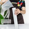 A hand pours a clear substance from a plastic mold into a white silicone mold for soap or candle making.