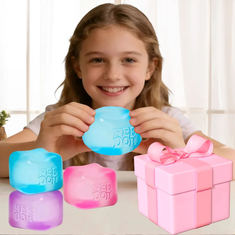 A girl holds and displays various translucent squishy fidget toys in blue, pink, and purple colors next to a pink gift box.