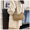 A beige PU square crossbody bag with a zipper closure is shown being held by a person wearing a light colored jacket.