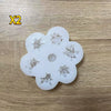 A set of white silicone molds shaped like flowers for baking, candle making, and soap production.