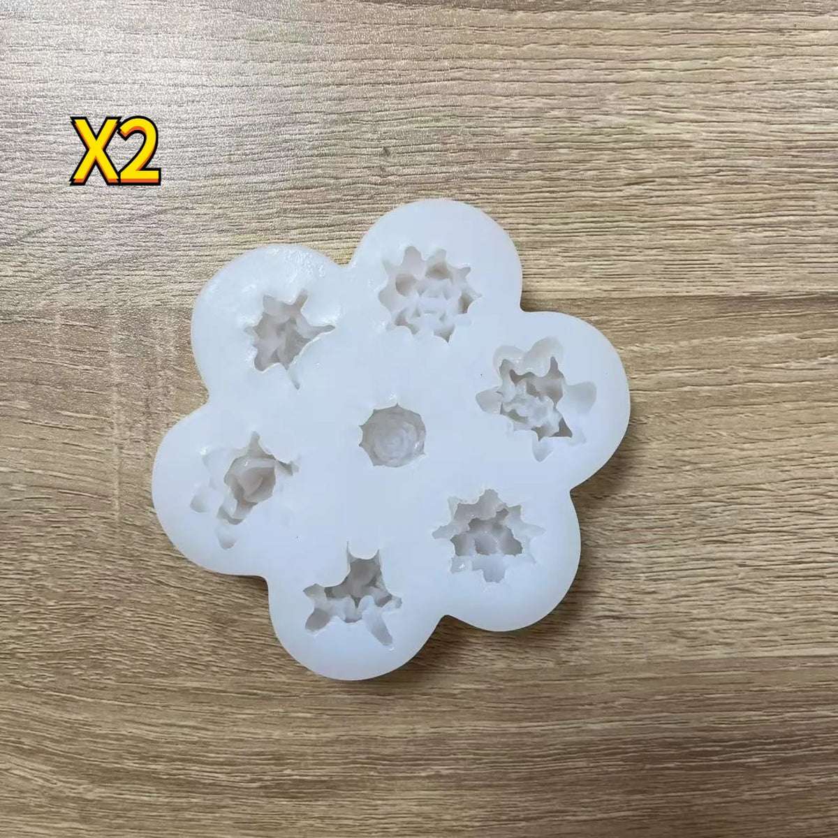 A set of white silicone molds shaped like flowers for baking, candle making, and soap production.
