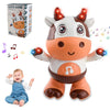 A cute, white and brown plush toy of a cow with glowing horns and musical notes, shown next to its packaging and a baby.