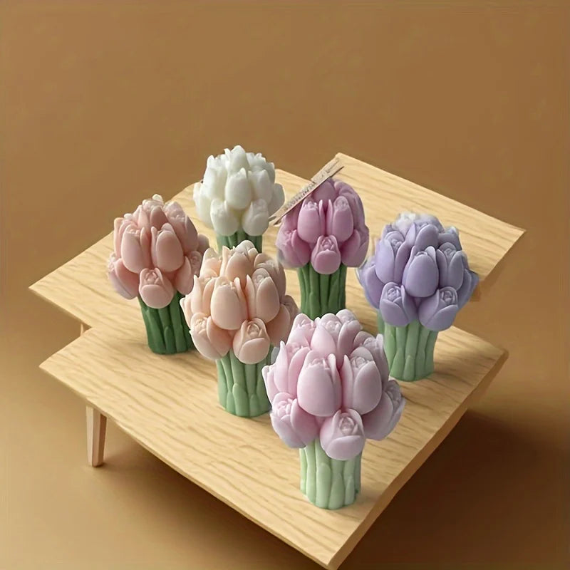 A collection of pink and purple silicone tulip flower molds arranged on a wooden surface.
