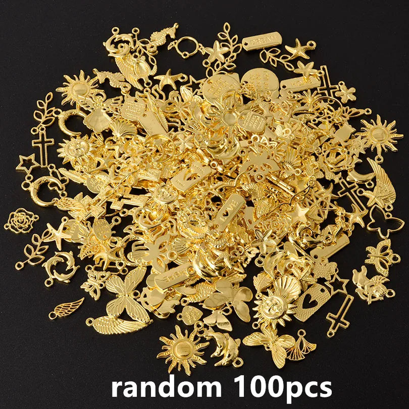 A pile of random gold metal charms and findings for DIY jewelry making