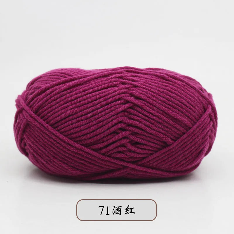 A ball of magenta pre-dyed milk cotton yarn used for knitting and crochet.