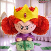 A collectible figure of Blossom from The Powerpuff Girls wearing a yellow crown and purple outfit, sitting on green money.