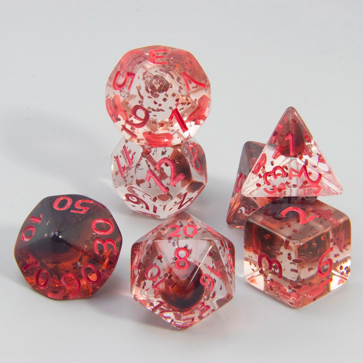 A set of translucent red and pink glitter polyhedral dice including a D4, D6, D8, D10, D12, and D20.